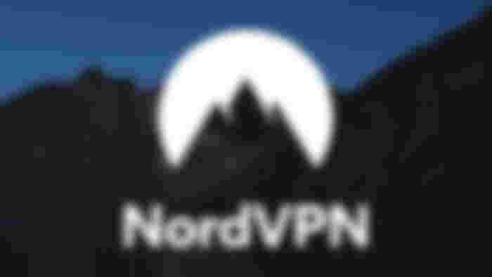 The NordVPN logo in white in front of a mountain and lake backdrop at night.