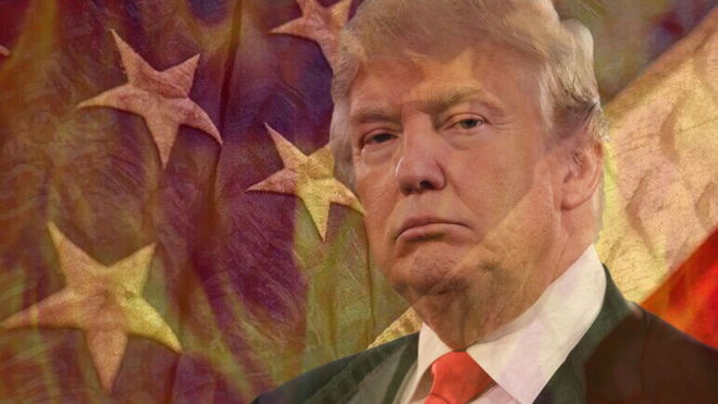 Donald Trump in focus behind a flaming wall and the starts on the American Flag