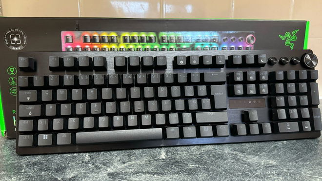 Razer Huntsman V3 Pro in front of its box and a tiled wall