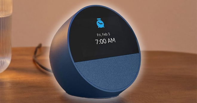A dark blue, circular smart alarm clock with a black screen with 7:00 AM shown on the display.
