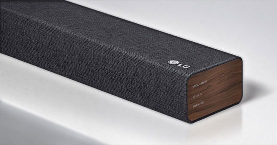 A dark grey LG soundbar with a dark wood panel on the end.