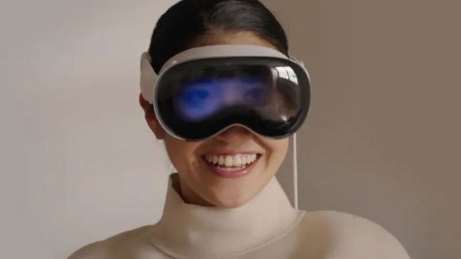 A woman gleefully smiling with the Apple Vision Pro on her face
