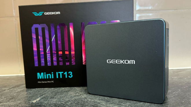 Geekom Mini IT13 in front of the box and a tiled wall