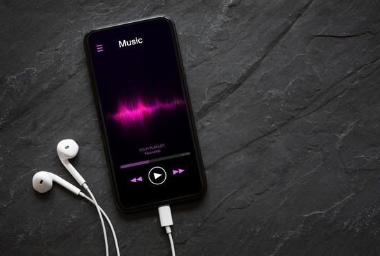 Apple Music vs Spotify - phone with headphones