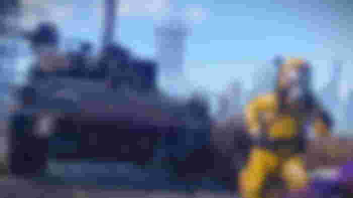Rust age rating - An image of a game character in a yellow outfit and a tank chasing them