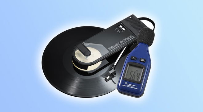 A black vinyl record turntable with a blue decibel meter next to it in front of a light blue background.