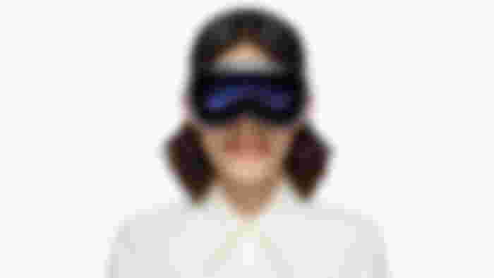 Someone wearing a white and black Apple Vision headset eyes showing through.