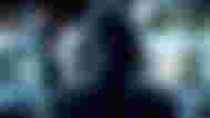 A hooded man looking at various augmented screens as an interpretation of hacking