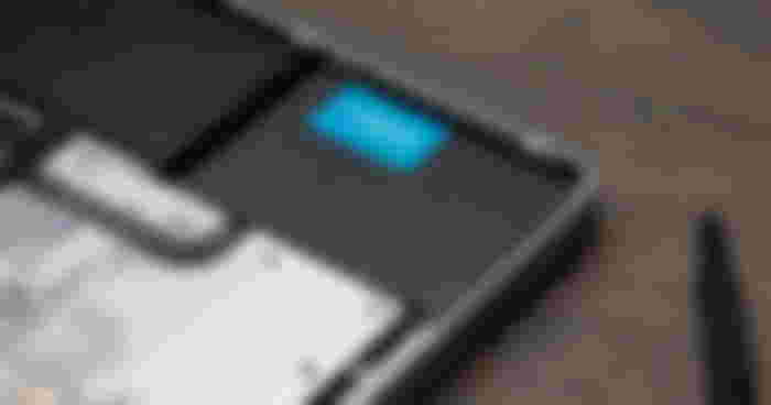A black, rectangular-shaped SSD featuring a blue label with white Crucial branding on top implanted into a laptop.