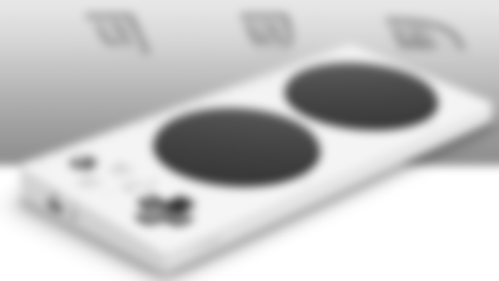 Xb1 Adaptive Controller product image of a flat white controller featuring two large black circles in the centre.