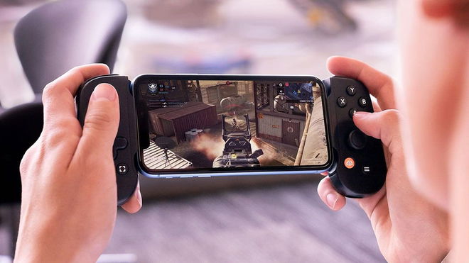 Someone playing an FPS game on their phone with two black sides of a controller connected on either end.