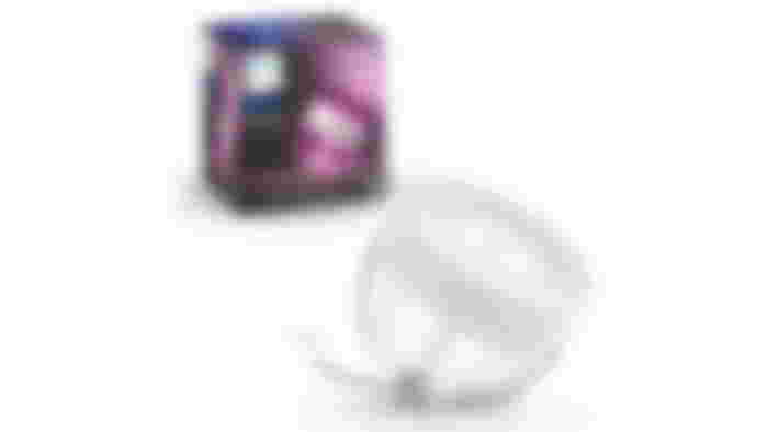 Philips Hue Iris product image of a white, cylindrical light facing upwards next to its box.