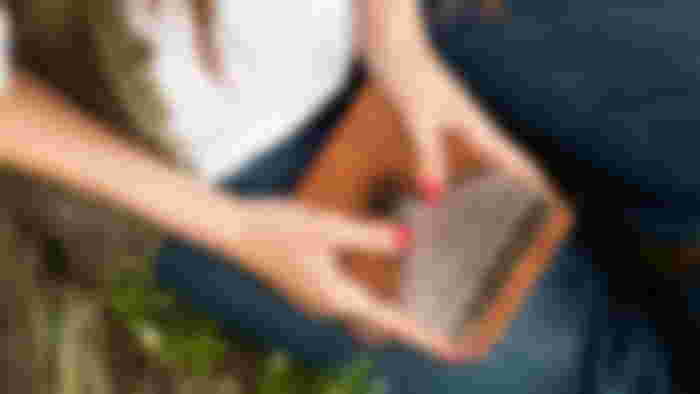 YUNDIE Kalimba Thumb Piano made of dark brown wood being played by someone with red painted nails.