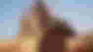 Dune Awakening player standing in front of monster in background