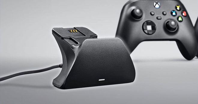 A black, wired charging stand sat ahead of a black Xbox controller.