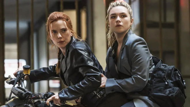 two women are riding on the back of a motorcycle