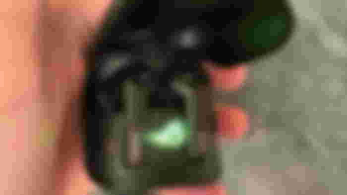 ASUS ROG Cetra earbuds in an open case with green ROG logo shining