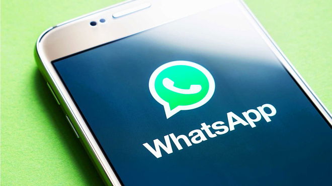 iPhone on a green background with the screen displaying the WhatsApp logo