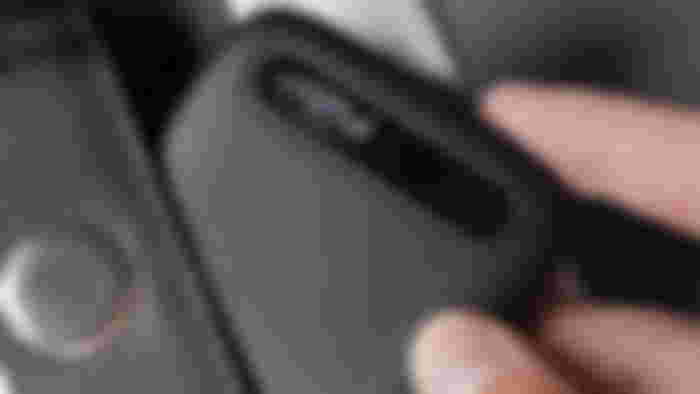 A black Crucial external SSD being placed in a pocket.