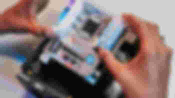 Someone installing a motherboard inside the Pantasy IGAME gaming desktop