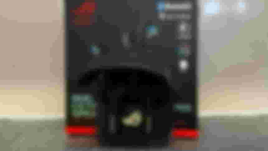 ASUS ROG Cetra earbuds inside the case in front of the box