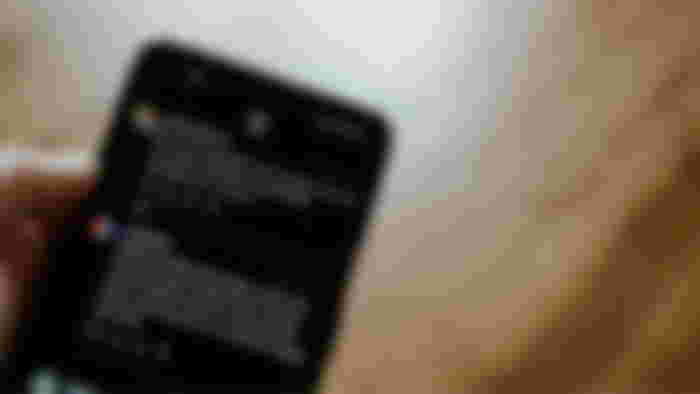 Instagram Threads with posts being scrolled through on a black smartphone.