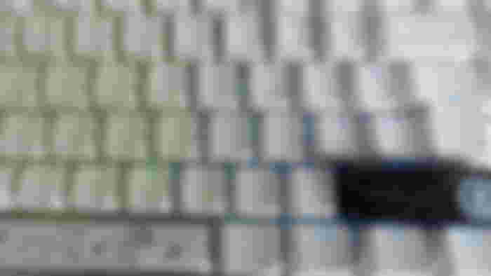 A close-up of the Ducky Zero 6108 Pure White keyboard with the keycaps shining in RGB and a RTX 4090 artisan keycap