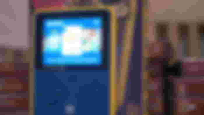 A HyperMegaTech Super Pocket Capcom Edition against a stack of evercade cases