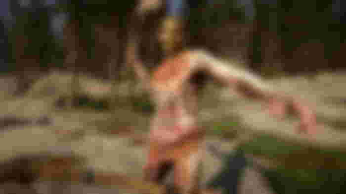 Image of DayZ player preparing to swing club with tall trees in background