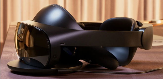A black VR headset with a cushioned back sat on a charging dock.