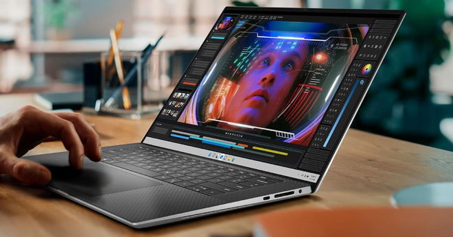 Someone using a thin black and silver laptop with editing software on the screen.
